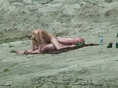Naked blonde is fucking aman on the beach  not knowing that someone is...