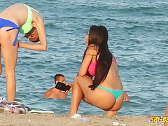 Adorable girls are having a great time on the beach while guys are che...